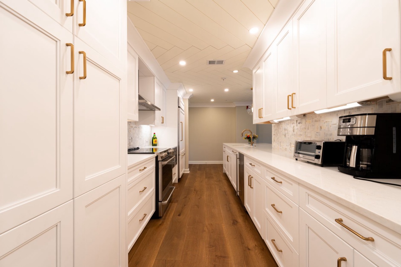 Newly renovated kitchen with white cabinetry and brass fittings